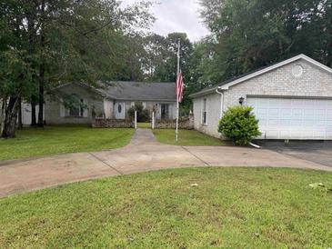 Charming one-story brick home with well-manicured lawn and mature trees at 318 Muirfield Rd., Myrtle Beach, SC 29588