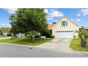 Charming single-story home featuring a manicured lawn and a two-car attached garage at 402 Bristlecone St., Longs, SC 29568