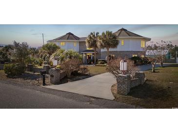 Unique round home with a brick and white exterior, palm trees, and a welcoming driveway at 4552 River Rd., Little River, SC 29566