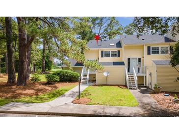 Charming townhome with a well-maintained lawn and inviting entryway staircase and yellow siding at 482 Greenview Dr. # 5B, Johnsonville, SC 29555
