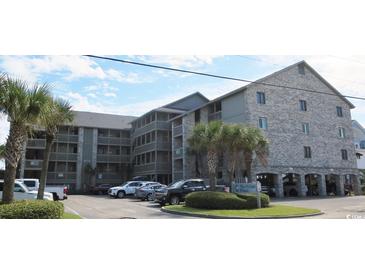 Attractive condo complex with a large parking area and palm trees offering a beach lifestyle at 618 N Waccamaw Dr. # B7, Garden City Beach, SC 29576