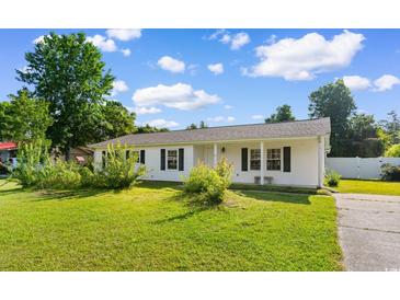 Charming home featuring well-maintained lawn, lovely front yard landscaping, and classic black shutters at 704 Bonnie Dr., Myrtle Beach, SC 29588