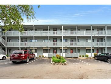 Three-story condo building featuring covered balconies and well-maintained landscaping at 7700 Porcher Dr. # 3205, Myrtle Beach, SC 29572