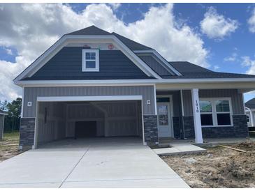New construction two-story home with a two-car garage featuring stone accents and a modern design at 1010 Black Locust Pl., Longs, SC 29568