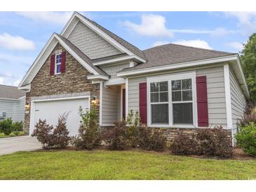 Charming home exterior with stone accents, gray siding, red shutters, and well-manicured landscaping at 124 Castaway Key Dr., Pawleys Island, SC 29585