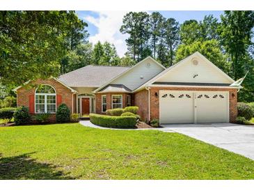 Charming brick home with a well-manicured lawn and a two-car garage at 1478 Bluegil Dr., Longs, SC 29568