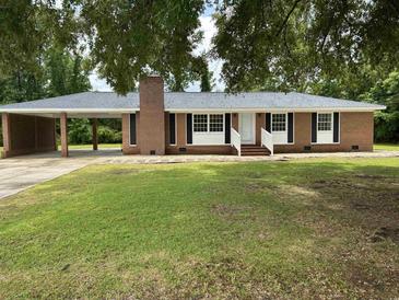 Charming brick home with a well-manicured lawn and attached carport at 189 Lewis Rd., Hemingway, SC 29554