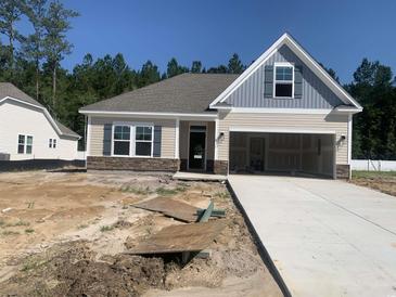 Charming single-story home featuring a neutral color palette, attached garage, and well-lit front entrance at 292 Palmetto Sand Loop, Conway, SC 29527