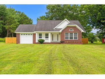 Charming single story brick home with attached garage and manicured front lawn at 2965 Mount Olive Rd., Loris, SC 29569