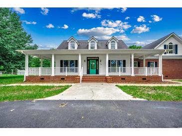 Inviting home showcasing a large front porch, white columns, dormer windows, and a teal front door at 391 William Nobles Rd., Aynor, SC 29511