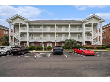 Three story condo building with multiple balconies and covered parking at 3951 Gladiola Ct. # 104, Myrtle Beach, SC 29588