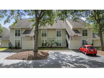 Charming exterior view of the two-story home showcasing the multiple windows and front parking at 4450 Little River Inn Ln. # 601, Little River, SC 29566