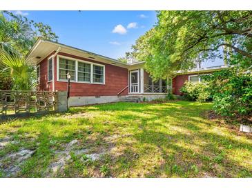 This home boasts a large backyard with screened porch and mature trees, perfect for outdoor living and relaxation at 506 28Th Ave. N, Myrtle Beach, SC 29577