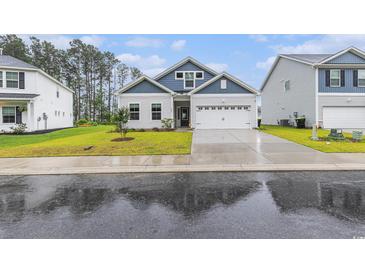 Charming home with a manicured lawn, two-car garage, and stylish blue and white siding at 628 Mccorkle Place, Conway, SC 29526