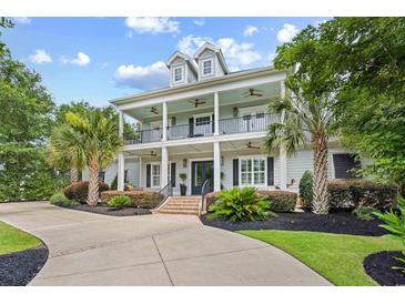 Beautiful two-story home with a charming double porch and well-manicured landscaping at 155 Preservation Circle, Pawleys Island, SC 29585
