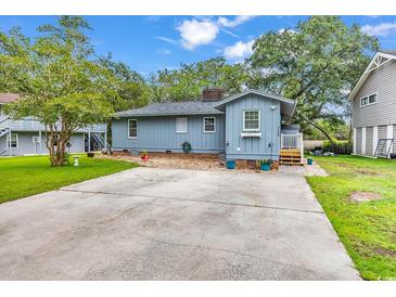 Charming home with a spacious backyard, mature trees, and a large driveway for easy parking at 2196 Liberty Circle, Little River, SC 29566