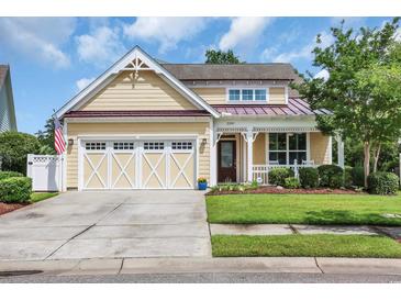 Charming two-story home showcasing a well-manicured lawn, a two-car garage, and an inviting front porch at 2199 Birchwood Circle, Myrtle Beach, SC 29577