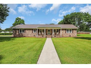 Charming brick home with a welcoming front porch and well-maintained lawn at 312 S Poplar Ave., Andrews, SC 29510
