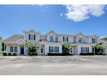 View of the townhomes with beige siding, blue shutters, and well-maintained landscaping at 105 Spring Creek Dr. # C, Myrtle Beach, SC 29588