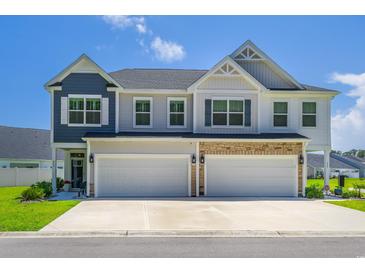 Beautiful two-story home featuring a two-car garage and manicured lawn under a clear blue sky at 215 Vivian St. Nw # 215, Calabash, NC 28467