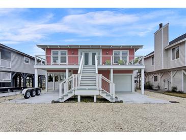 Charming raised beach house with white stairs, a garage, and a waterfront view at 25 Newport St., Ocean Isle Beach, NC 28469