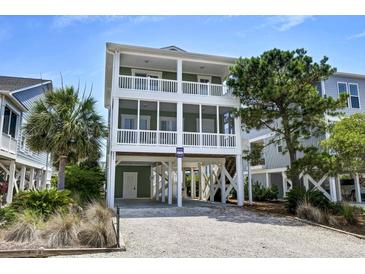 Inviting raised beach home featuring dual screened porches and charming coastal curb appeal at 421 30Th Ave. S, Sunset Beach, NC 28468