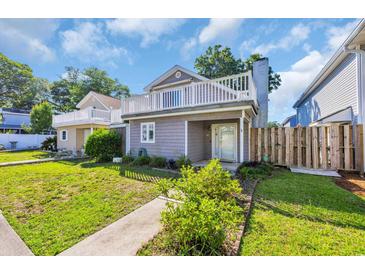 Charming exterior of a two-story home showcasing a white picket fence and well-manicured lawn at 510 Rosemary Ln., North Myrtle Beach, SC 29582