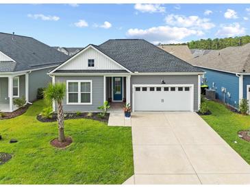 Charming home featuring well-manicured lawn, a two-car garage and inviting front entrance with beautiful landscaping at 6304 Chadderton Circle, Myrtle Beach, SC 29579