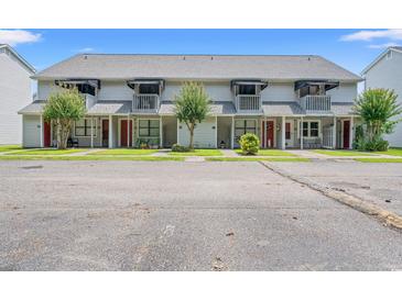 Charming townhomes featuring private balconies and well-maintained lawns under a clear blue sky at 801 Burcale Rd. # K7, Myrtle Beach, SC 29579