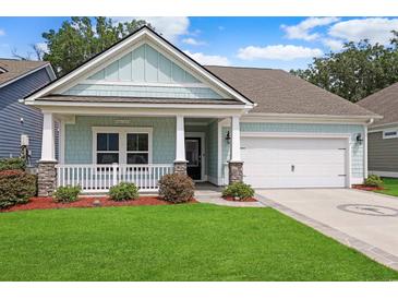 Charming single-story home featuring a quaint front porch, well-manicured lawn, and attached two car garage at 865 Summer Starling Pl., Myrtle Beach, SC 29577
