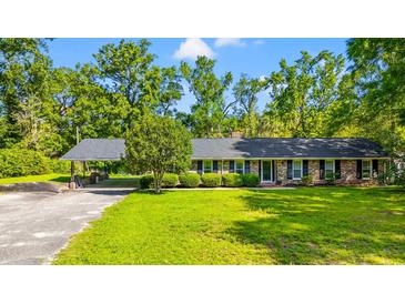 Charming brick ranch with a covered carport, lush lawn, and mature landscaping at 1032 Chelsey Circle, Conway, SC 29526