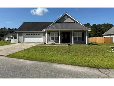 Charming single-story home with a well-manicured lawn and a two-car garage at 140 Blue Pride Dr., Loris, SC 29569