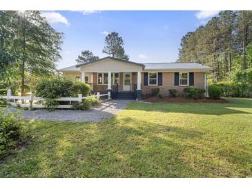 Charming brick home featuring a well-maintained lawn and a classic white picket fence at 3269 Sims Rd., Marion, SC 29571