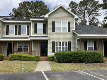 Charming two-story home featuring a covered front porch and well-maintained landscaping at 4840 Moss Creek Loop # 31, Murrells Inlet, SC 29576