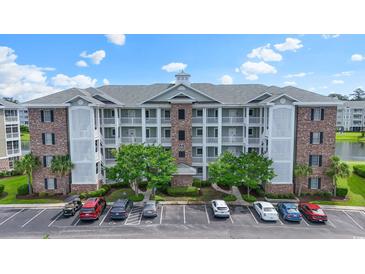 Attractive condo building with balconies, brick accents, and well-maintained landscaping and convenient parking at 4887 Luster Leaf Circle # 104, Myrtle Beach, SC 29572