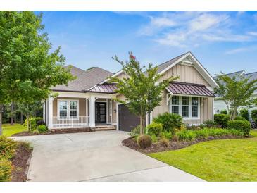 Charming single-story home featuring a well-manicured lawn, stylish porch, and attached garage at 496 Starlit Way, Myrtle Beach, SC 29579