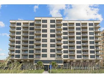 Beautiful multi-story beachfront condo building with private balconies and manicured landscaping at 523 S Ocean Blvd. # 305, North Myrtle Beach, SC 29582
