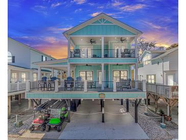 Stunning two-story home with balconies, outdoor seating, and parking for golf carts underneath at 6001 - 1195 S Kings Hwy., Myrtle Beach, SC 29575
