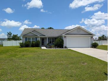 Charming single-story home with a well-manicured lawn and attached two car garage at 671 American Beech St., Loris, SC 29569