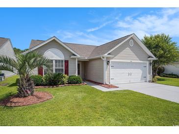 Charming single-story home with well-manicured lawn and two-car garage on a bright day at 946 Wyndfall Dr., Sunset Beach, NC 28468