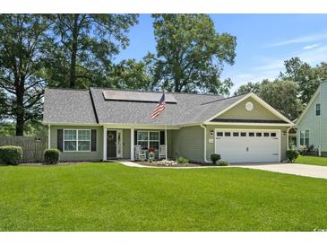Well-maintained home with green lawn, solar panels, and American flag at 1100 Rosetta Dr., Conway, SC 29526