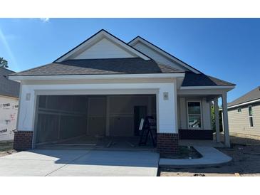New construction home with a spacious two-car garage and a modern exterior design under a sunny sky at 1221 Lady Bird Way, North Myrtle Beach, SC 29582