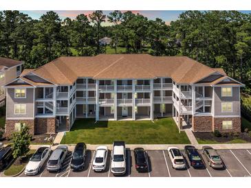 Three-story condo building featuring white railings, a well-manicured lawn, and convenient parking at 125 South Shore Dr. # 204, Longs, SC 29568