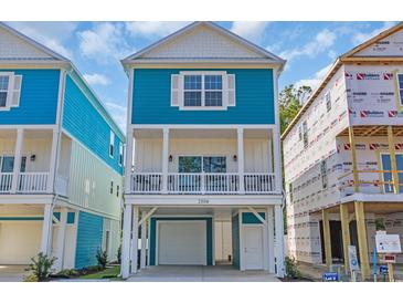 Charming raised beach home featuring a light blue exterior, white trim, and covered porch at 2308 Seaseeker Ln., Myrtle Beach, SC 29577