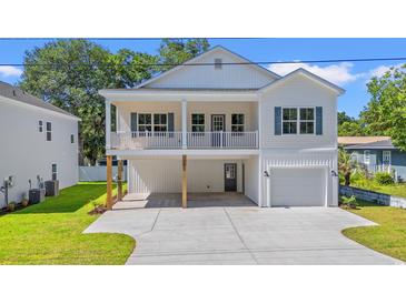 Charming two-story white home featuring a covered porch, attached garage, and well-maintained lawn at 2426 Park St., North Myrtle Beach, SC 29582