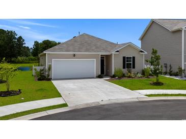 Inviting single-story home with a pristine lawn, attached garage, and beautiful landscaping at 326 Picnic Basket Pl., Longs, SC 29568