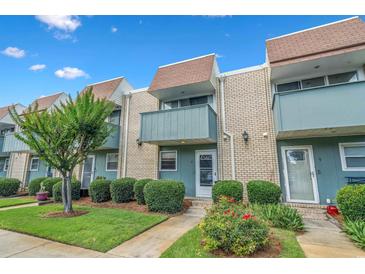Charming townhouse with brick facade, blue trim, small balconies, and well-maintained landscaping at 4701 N Kings Hwy. # 8, Myrtle Beach, SC 29577
