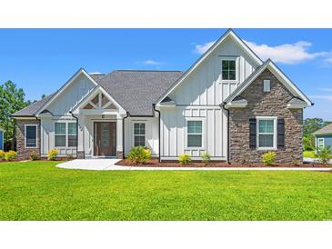 Charming home with white siding, stone accents, manicured lawn, and inviting front entrance at 609 Mccown Dr., Conway, SC 29526