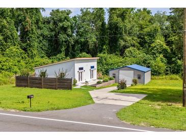 Modern home featuring a well-maintained lawn, an outbuilding and a stylish, minimalist design at 709 Highway 90, Conway, SC 29526
