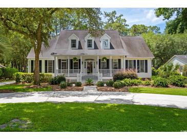 Charming home with a welcoming front porch, manicured landscaping, and a long driveway at 77 Capt Anthony White Ln., Georgetown, SC 29440